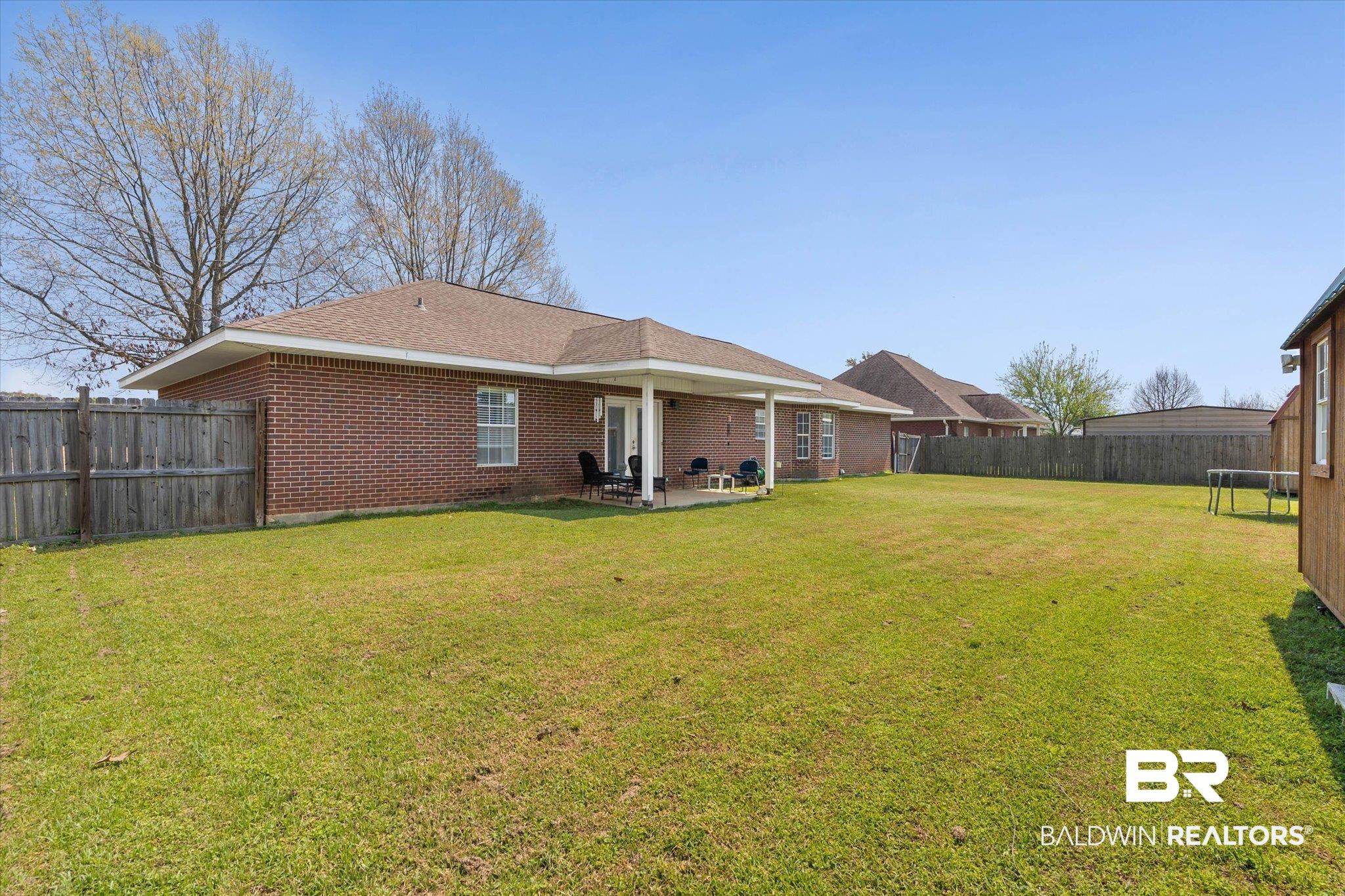 22095 Buck Road Robertsdale, AL 36567 - Photo 19 of 22 Rear view of property with a fenced backyard, a patio, brick siding, and a shingled roof