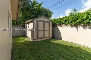 a view of backyard with potted plants and a large tree