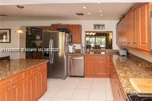 a kitchen with stainless steel appliances granite countertop a refrigerator and a stove