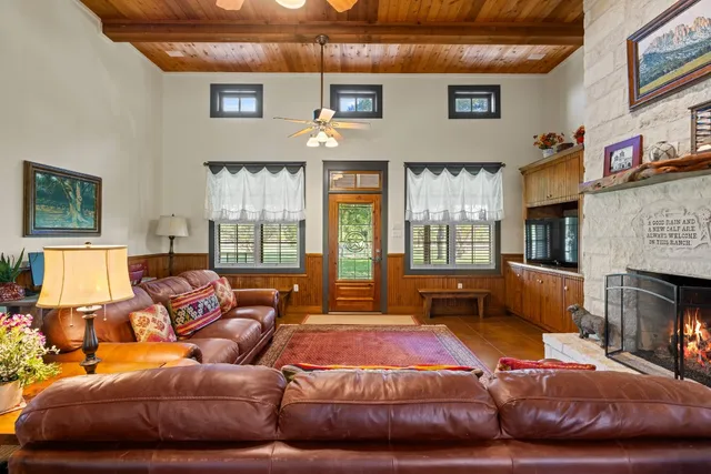 a living room with furniture a fireplace and a floor to ceiling window