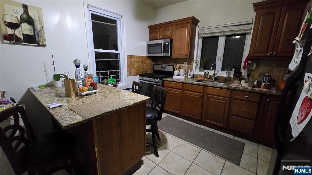 106 Knapp Avenue Clifton, NJ 07011 - Photo 2 of 7 a kitchen with a stove a sink and a refrigerator