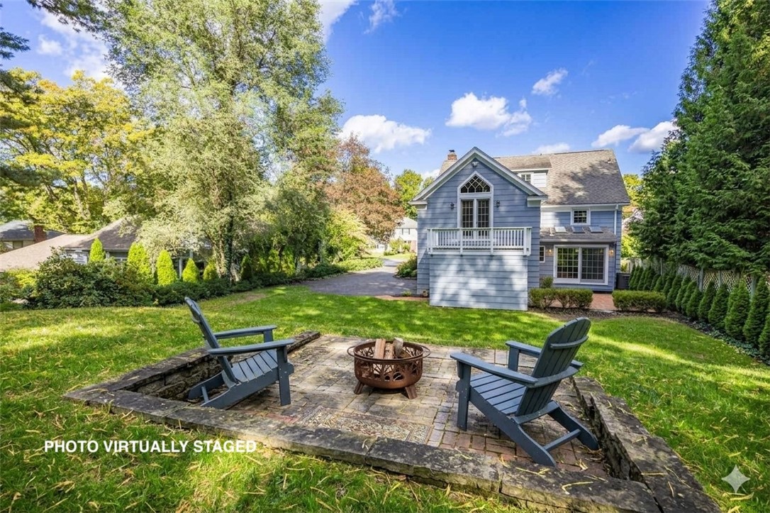 387 Kilbourn Road Rochester, NY 14618 - Photo 32 of 42 Photo Virtually Staged -A spacious green lawn surrounds a stone patio complete with a central fire pit.