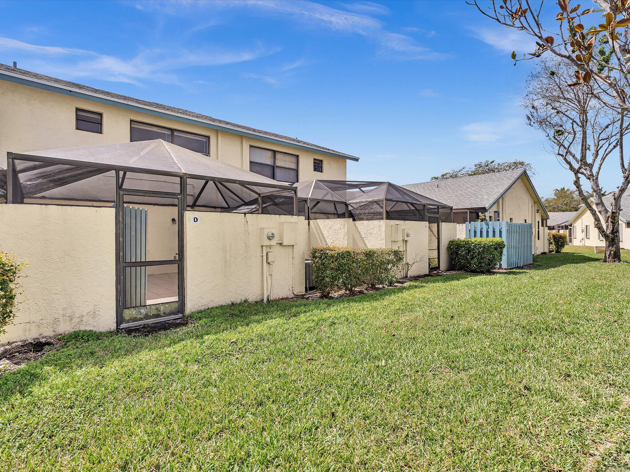 9095 Southwest 21st Court, Unit D Boca Raton, FL 33428 - Photo 15 of 36 a front view of a house with a yard and garage