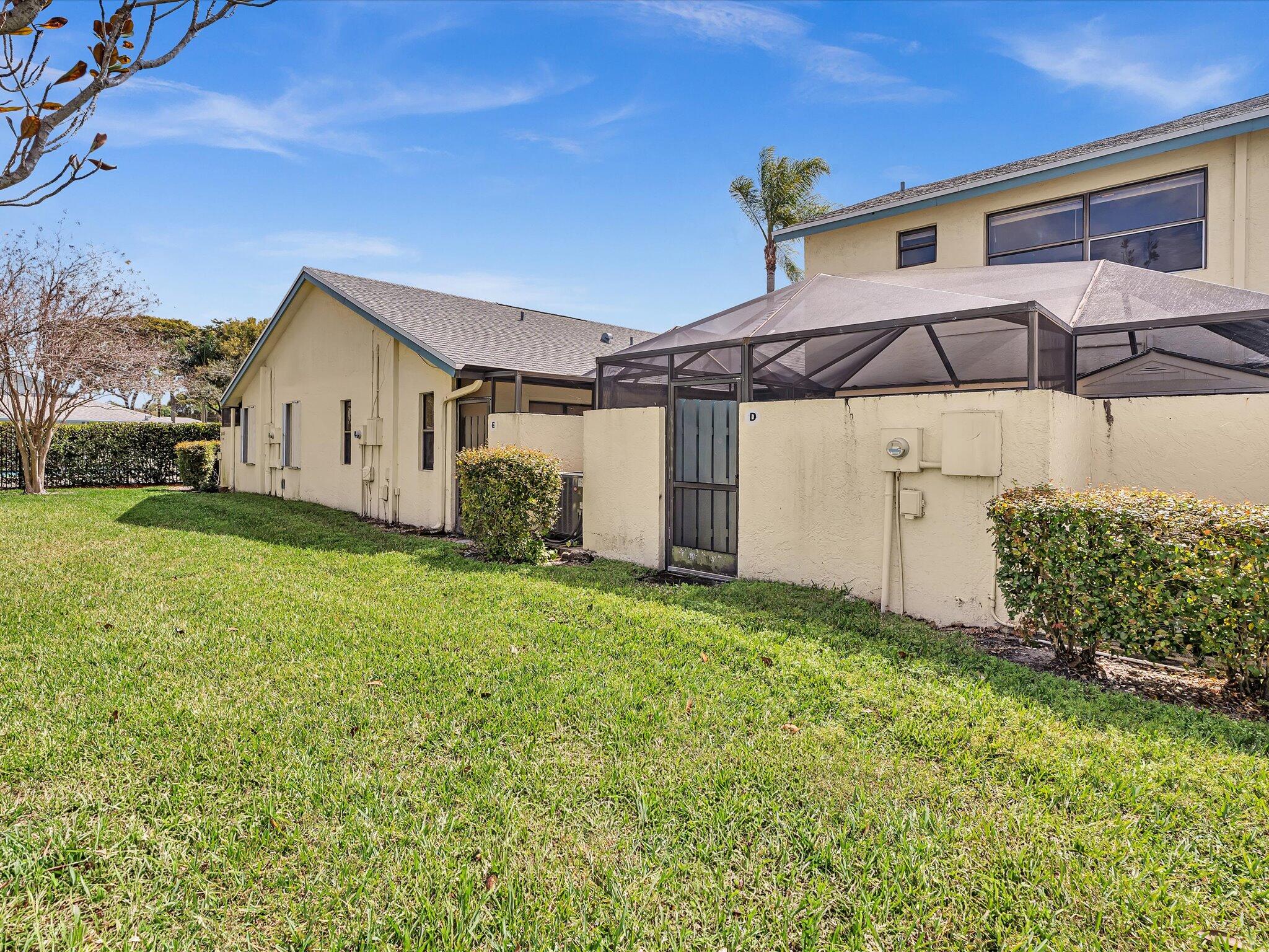 9095 Southwest 21st Court, Unit D Boca Raton, FL 33428 - Photo 16 of 36 a front view of a house with garden