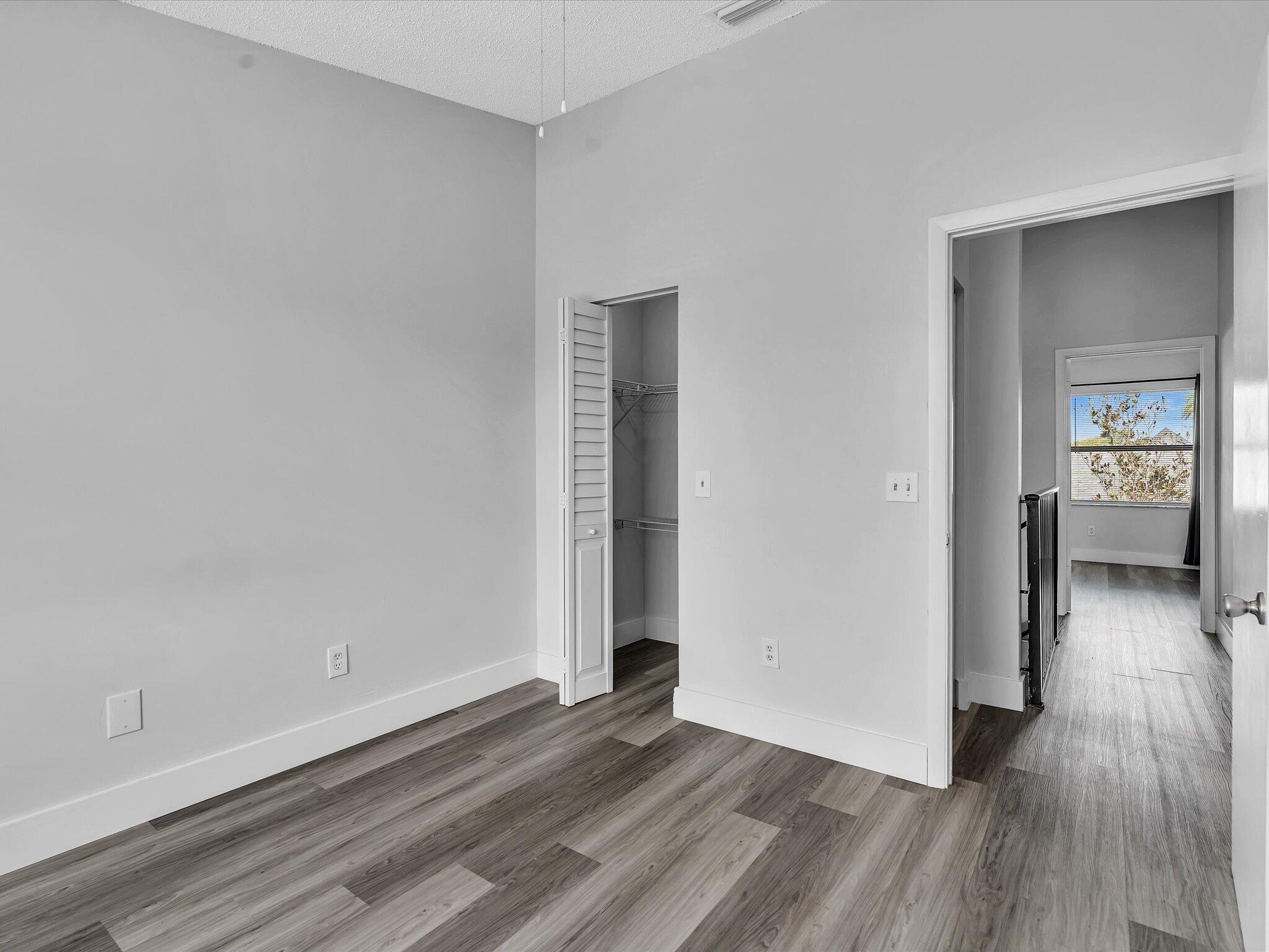 9095 Southwest 21st Court, Unit D Boca Raton, FL 33428 - Photo 20 of 36 wooden floor in a hall with an empty room