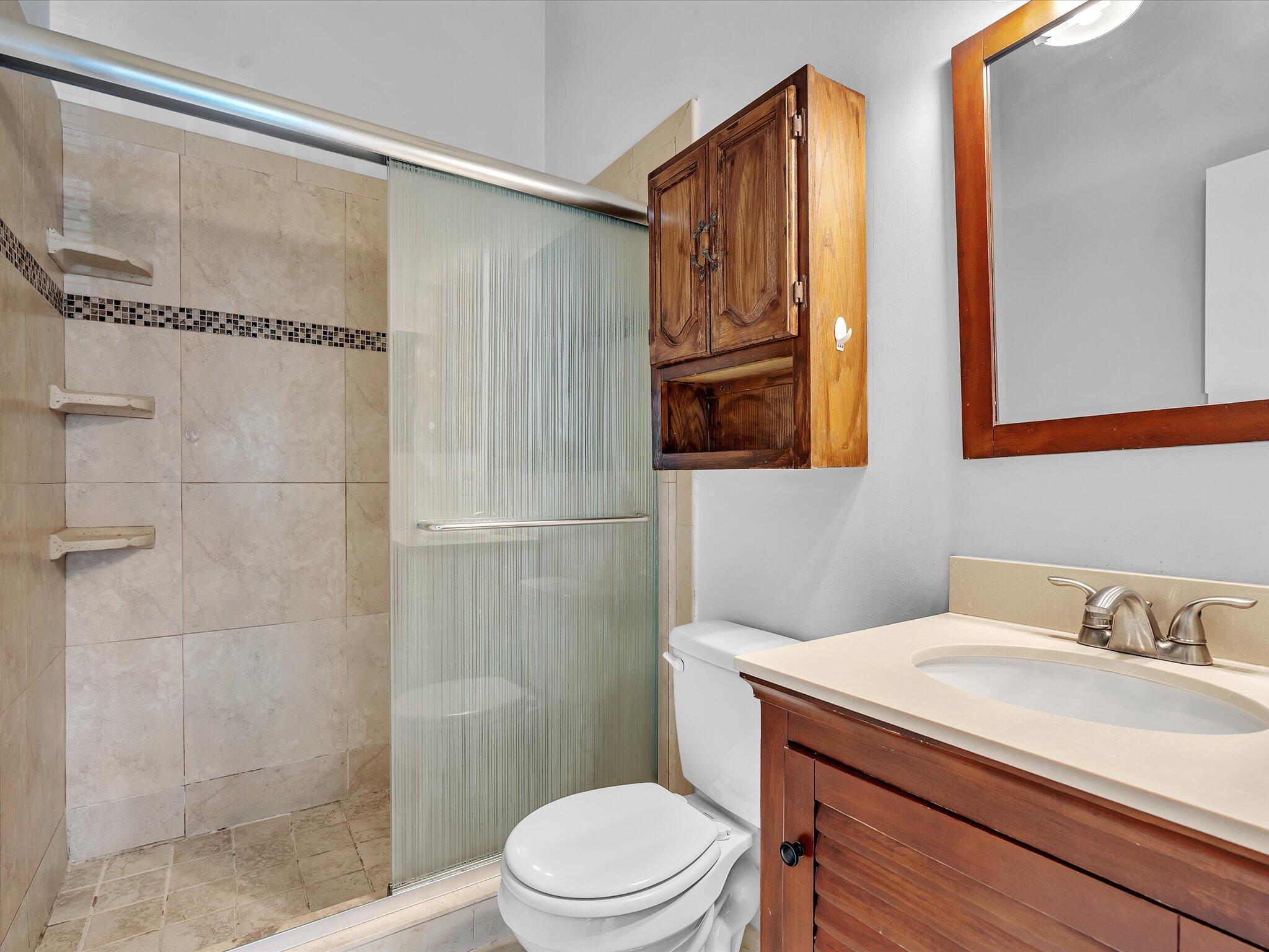 9095 Southwest 21st Court, Unit D Boca Raton, FL 33428 - Photo 23 of 36 a bathroom with a sink a toilet and shower