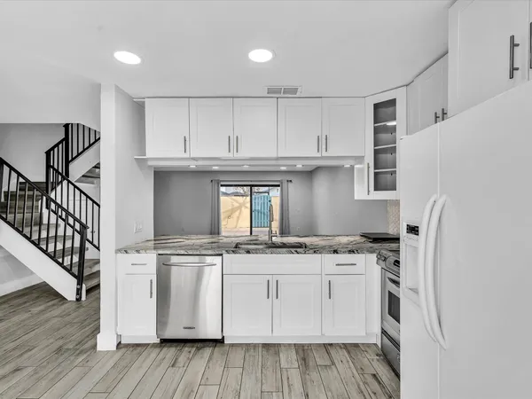 a kitchen with stainless steel appliances granite countertop a stove and a refrigerator