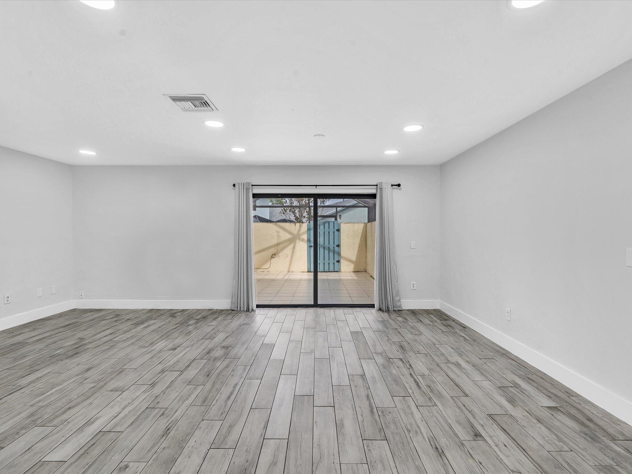 9095 Southwest 21st Court, Unit D Boca Raton, FL 33428 - Photo 8 of 36 a view of an empty room with wooden floor and a window