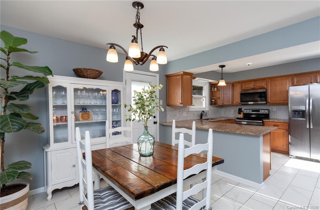 16156 Tana Tea Circle Fort Mill, SC 29708 - Photo 8 of 29 a view of a dining room with furniture a kitchen and chandelier