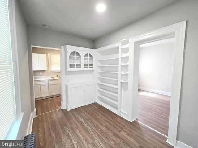 a view of a walk in closet and bedroom with wooden floor