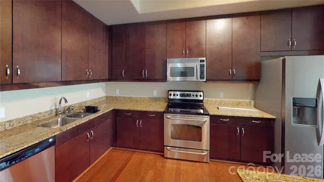 a kitchen with wooden cabinets and stainless steel appliances
