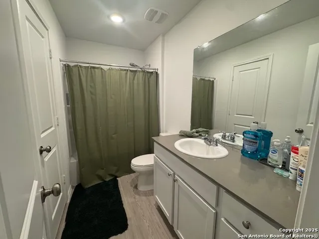 a bathroom with a sink a toilet a mirror and shower
