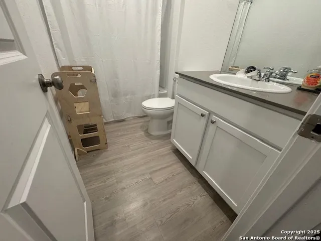 a bathroom with a sink a toilet a mirror and shower