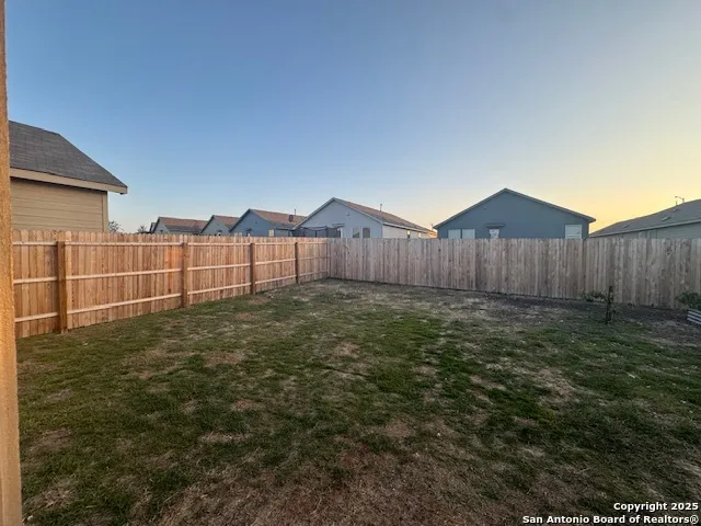 a view of a backyard with wooden fence