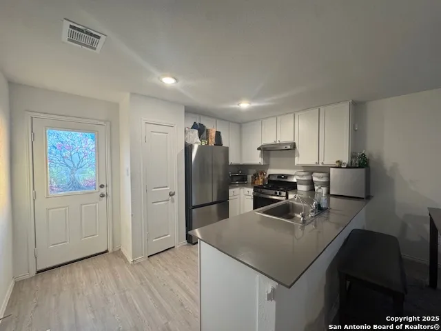 a kitchen with refrigerator cabinets and wooden floor