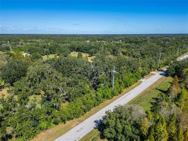 a view of a green field with lots of bushes