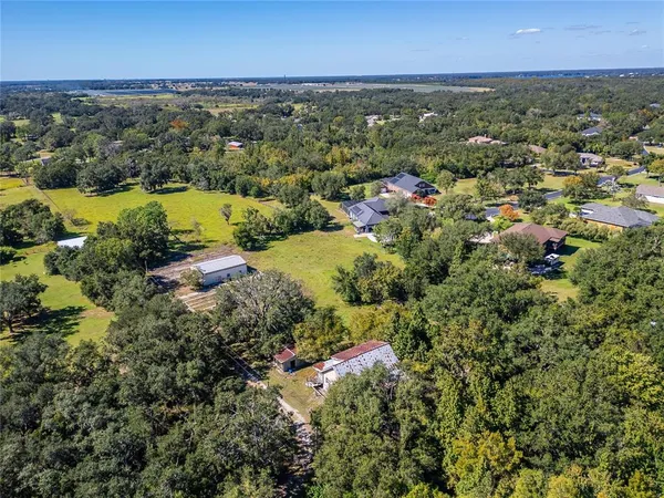 an aerial view of residential houses with outdoor space and lake view