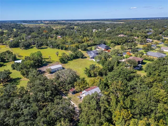 an aerial view of residential houses with outdoor space and lake view