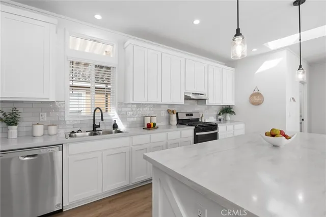 a kitchen with white cabinets and sink