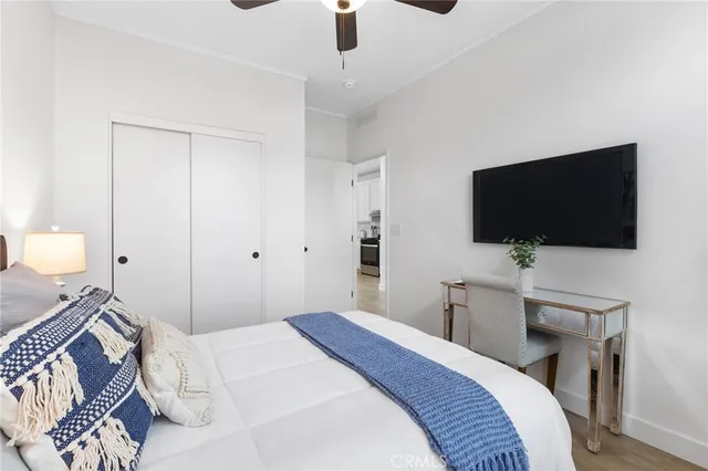 a bedroom with a bed and a flat tv screen on wall