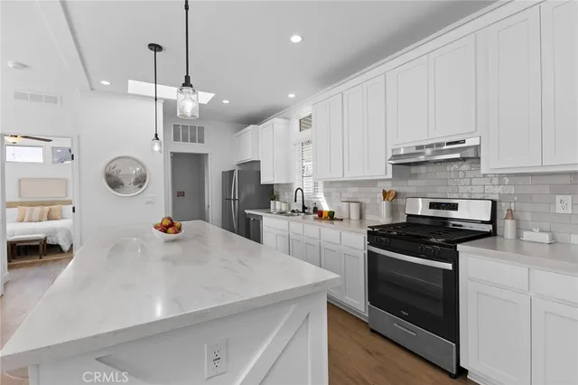 a kitchen with kitchen island a stove sink and cabinets