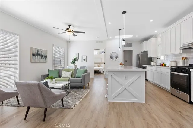 a living room with kitchen island furniture and a chandelier