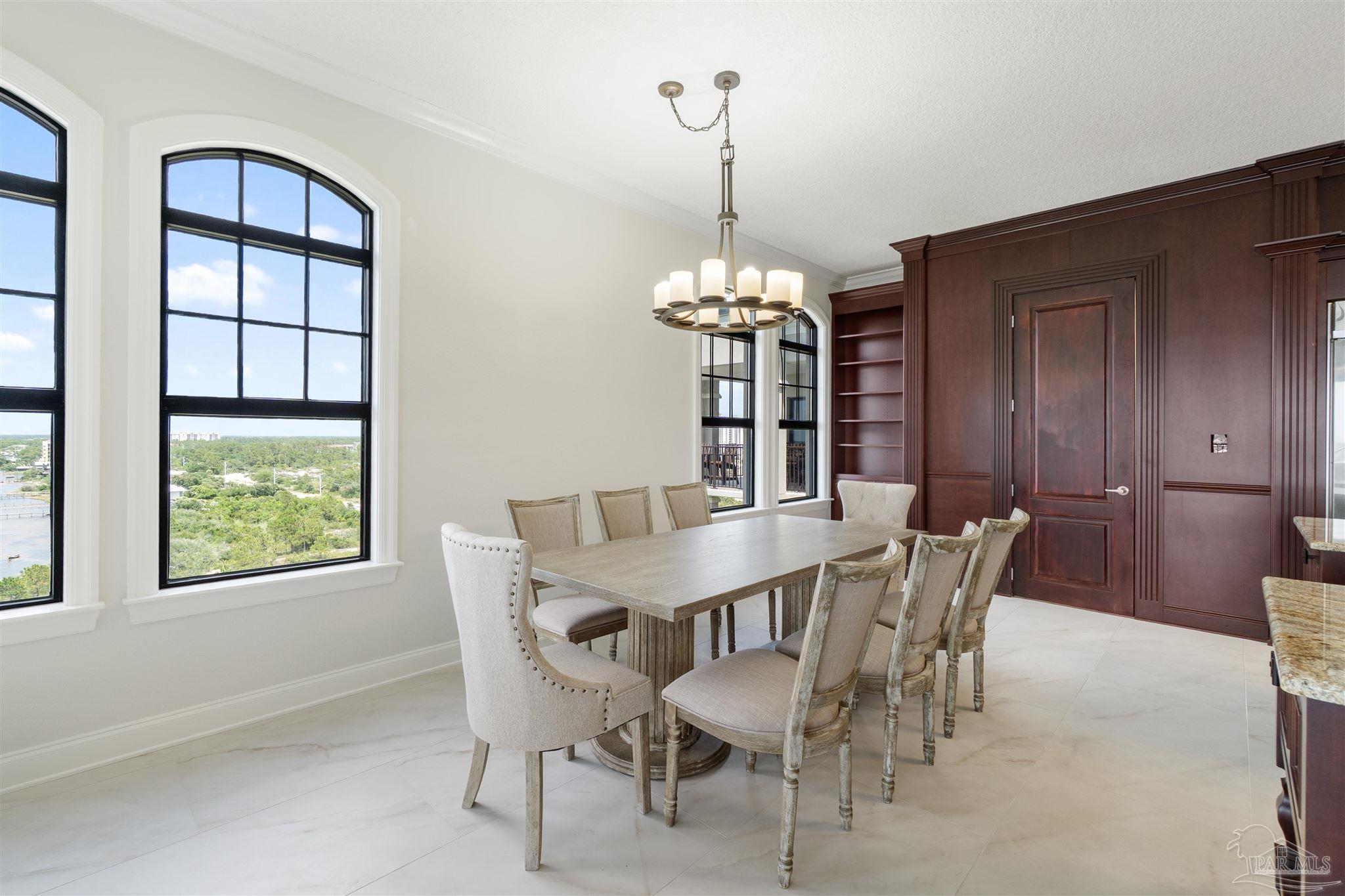 14900 River Road, Unit 904 Pensacola, FL 32507 - Photo 5 of 17 a view of a dining room with furniture and chandelier