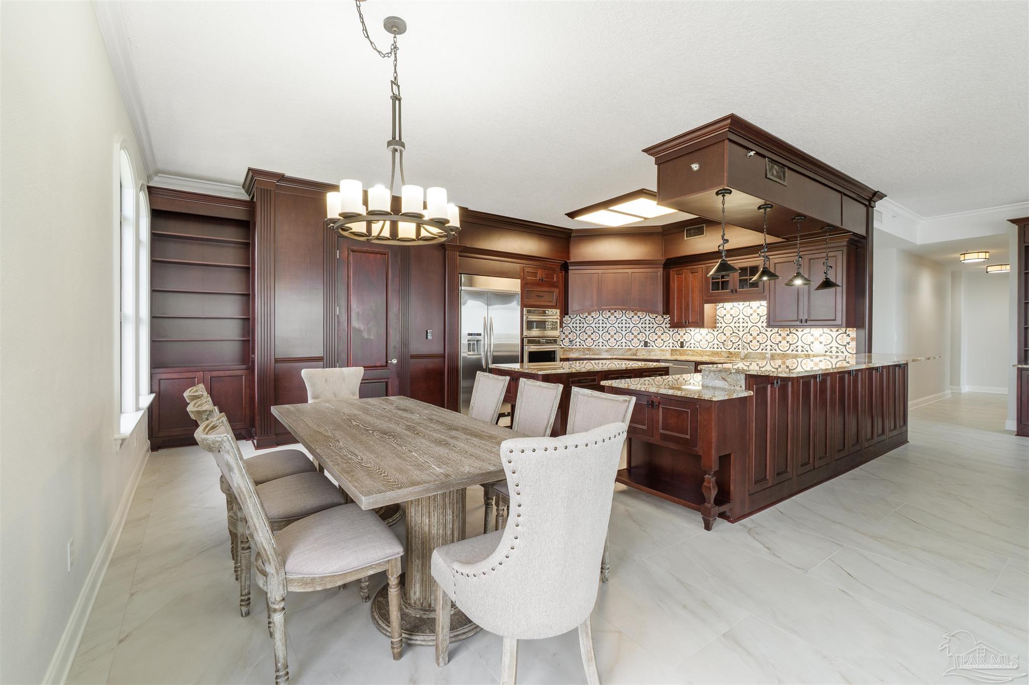 14900 River Road, Unit 904 Pensacola, FL 32507 - Photo 6 of 17 a view of a dining room with furniture and chandelier