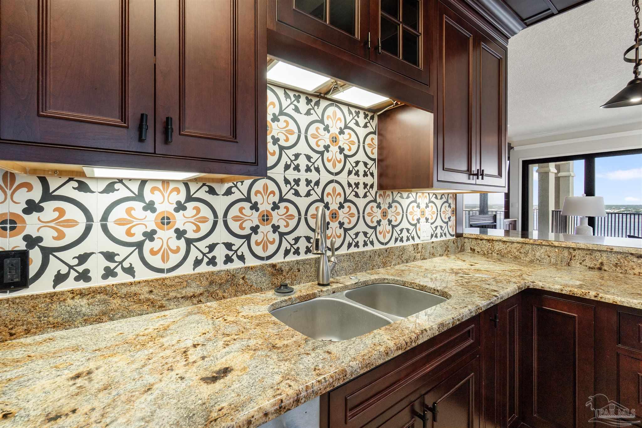 14900 River Road, Unit 904 Pensacola, FL 32507 - Photo 10 of 17 a kitchen with granite countertop sink and cabinets