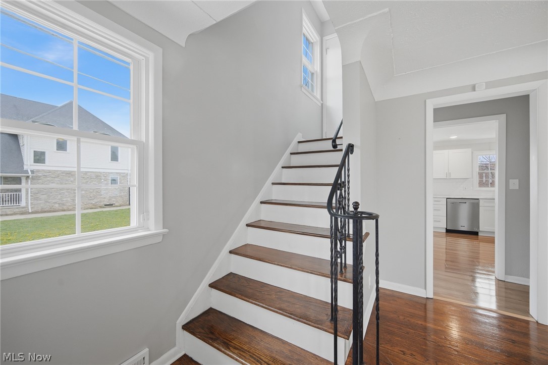 3722 Lindholm Road Shaker Heights, OH 44120 - Photo 19 of 34 The property features a staircase with dark wood treads and a black wrought iron handrail, and a window with white trim