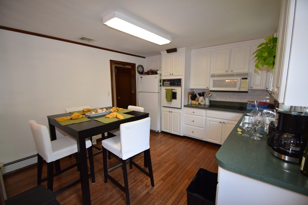 7 Van Beal Road Randolph, MA 02368 - Photo 6 of 22 a kitchen with stainless steel appliances kitchen island granite countertop a table chairs and a refrigerator
