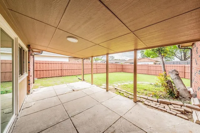 a view of an empty room with a floor to ceiling window next to a yard