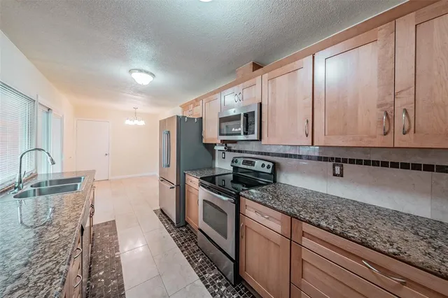 a kitchen with stainless steel appliances granite countertop a sink stove and microwave