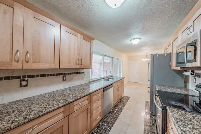 a kitchen with stainless steel appliances granite countertop a sink stove and cabinets