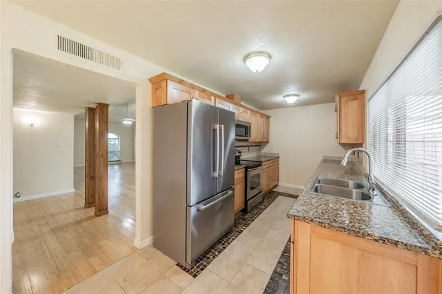 a kitchen with granite countertop a refrigerator and a sink