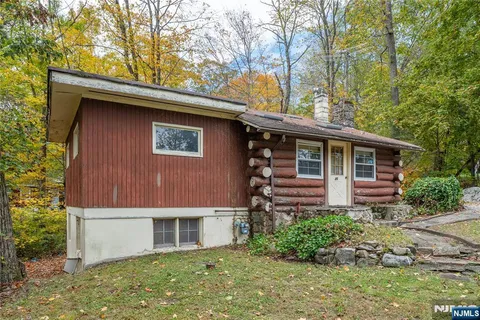 a front view of house with yard and trees around