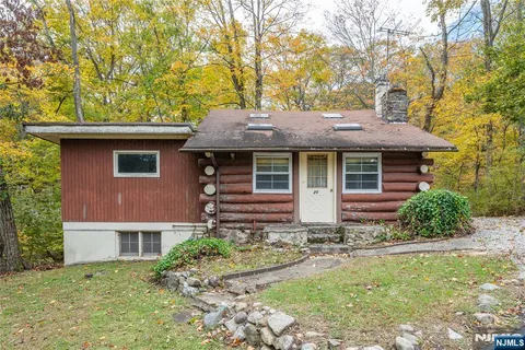 a front view of house with yard and trees around