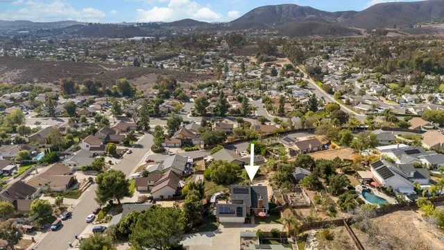 an aerial view of residential houses with outdoor space and trees