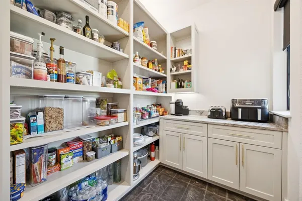 a utility room with stainless steel appliances cabinets and baby crib
