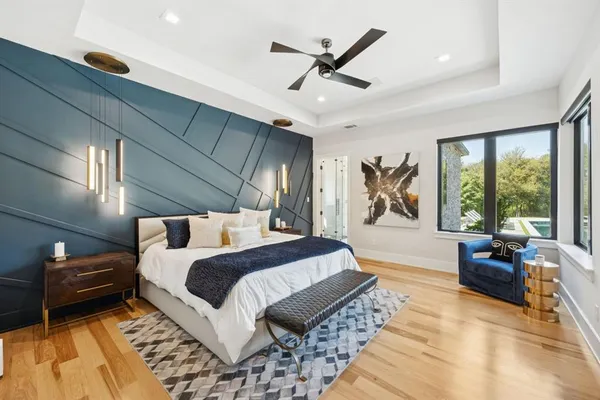 a spacious bedroom with a bed a couch and a large window