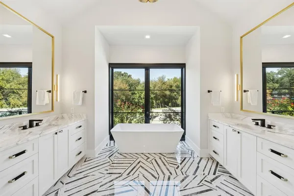 a spacious bathroom with a double vanity sink a mirror and a bathtub