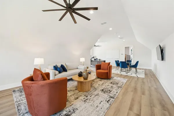 a living room with furniture and a wooden floor