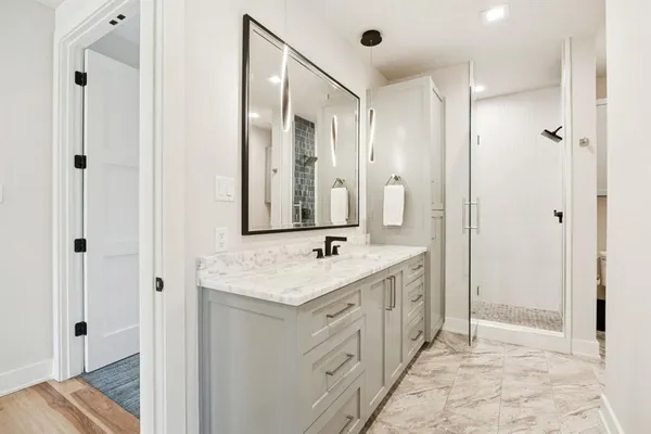 a bathroom with a double vanity sink mirror and shower