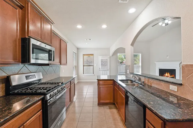 a large kitchen with stainless steel appliances granite countertop a stove and a sink