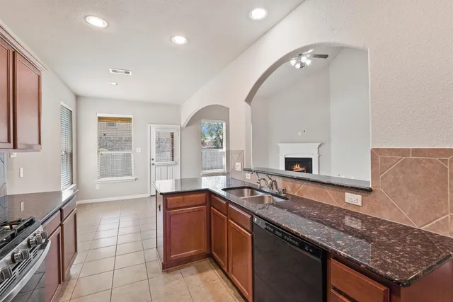 a large kitchen with granite countertop a sink and a stove