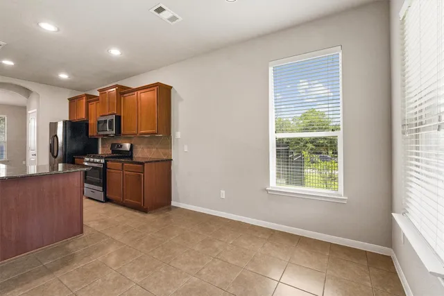 a kitchen with stainless steel appliances a refrigerator and a stove top oven