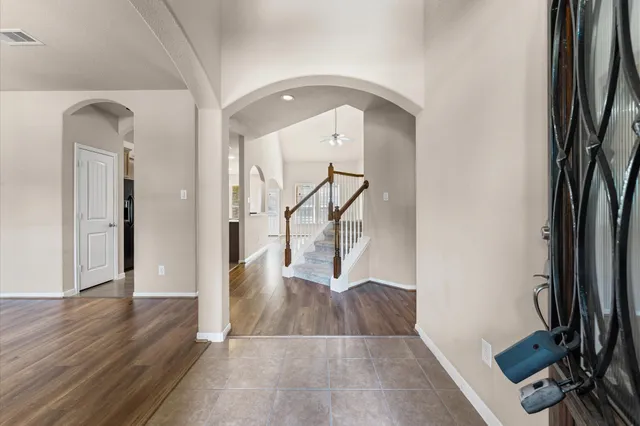a view of a hallway with wooden floor and a living room