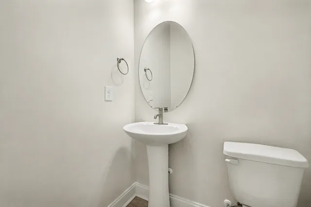 a bathroom with a toilet a sink and mirror