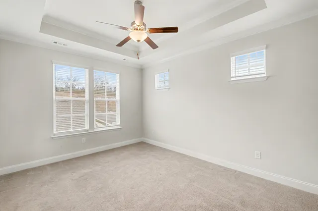 an empty room with a window and a ceiling fan