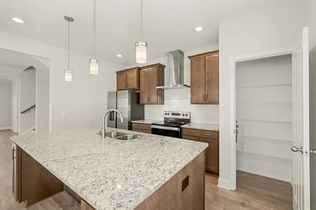 a kitchen with kitchen island a counter top space appliances and a sink